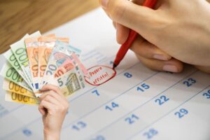 calendario con segnato il pagamento dell'affitto e mano con banconote euro